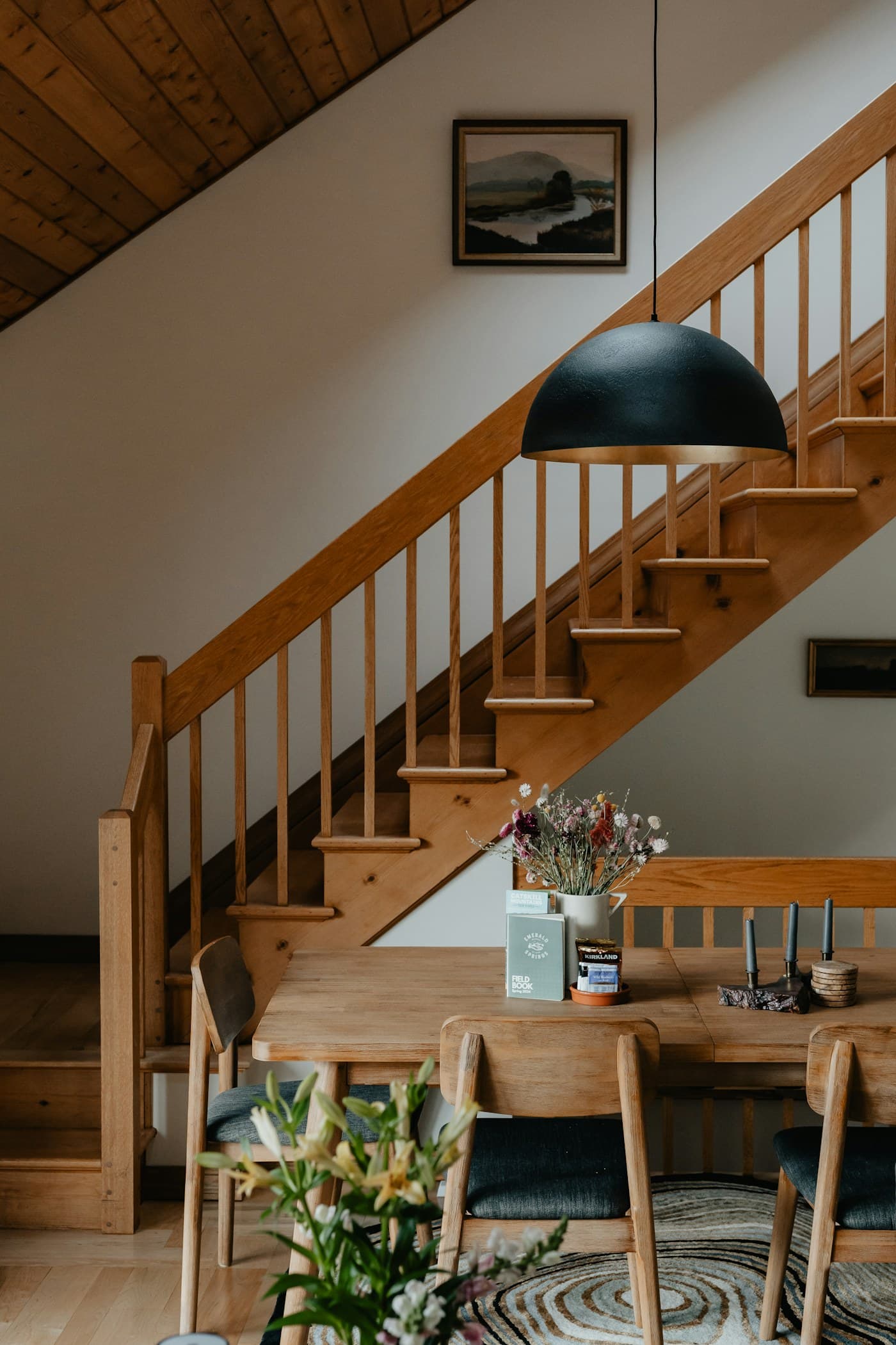 Oak table beneath the staircase, lit from the court