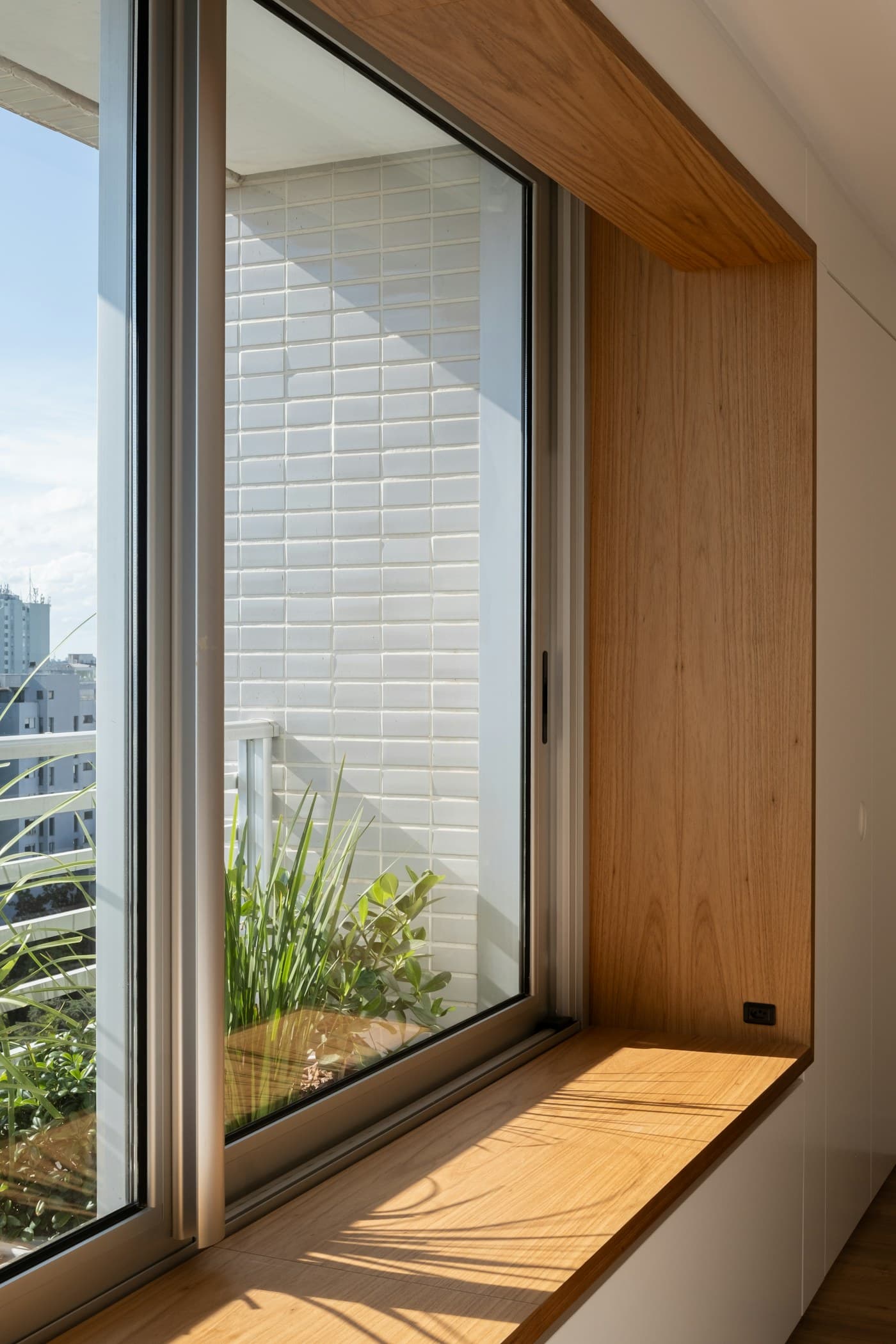 Teak window seat with plants, catching the morning light