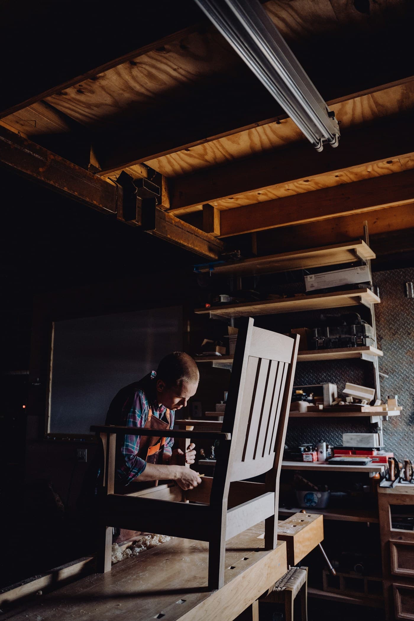 Craftsman shaping a chair in the workshop